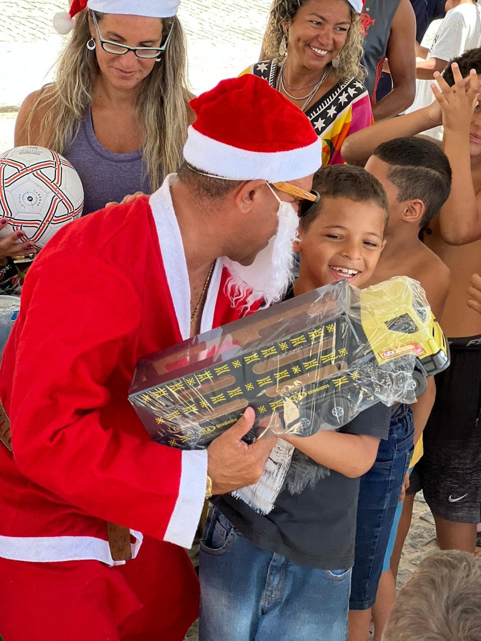 Ação da Recreio Solidário entregando presentes de Natal para crianças da comunidade.